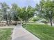 Scenic view of a park with lush green grass, mature trees, a sidewalk, and park benches at 3476 Ridge Meadow St, Las Vegas, NV 89135