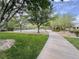 Scenic walking path through community green space with lush landscaping, trees, and a view of the basketball court at 3476 Ridge Meadow St, Las Vegas, NV 89135