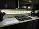 Close up of modern kitchen with gas stovetop, white quartz counters and block-style backsplash at 3805 White Castle St, Las Vegas, NV 89129