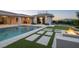Outdoor oasis showcasing a pool, a fire pit, lush greenery, and a covered patio, ideal for relaxation at 4070 N Tee Pee Ln, Las Vegas, NV 89129