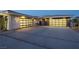 Expansive driveway leads to two two-car garages with modern doors, stone accents and desert landscaping at 4070 N Tee Pee Ln, Las Vegas, NV 89129