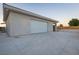 Exterior view of the garage showcasing a large concrete driveway and landscaping at 4070 N Tee Pee Ln, Las Vegas, NV 89129