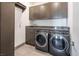 Laundry room with modern washer and dryer, built-in cabinets and counters for storage at 4070 N Tee Pee Ln, Las Vegas, NV 89129