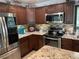 Updated kitchen featuring granite counters, stainless steel appliances, and dark wood cabinets at 4125 Tyrol Way, Las Vegas, NV 89124