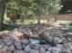 Scenic view of a rock-lined pond with a small waterfall feature amidst mature trees at 4125 Tyrol Way, Las Vegas, NV 89124