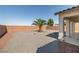 Low-maintenance backyard with gravel landscaping, palm tree, and partially covered patio at 4410 S Gressa St, Pahrump, NV 89061