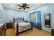 Blue bedroom featuring a ceiling fan, wood-look floors, and ample natural light at 4410 S Gressa St, Pahrump, NV 89061