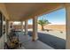 Covered patio showing outdoor seating area and view of the gravel backyard with palm tree at 4410 S Gressa St, Pahrump, NV 89061
