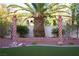 Backyard featuring artificial turf, palm trees, and decorative pillars for a serene outdoor space at 4554 Blue Mesa Way, Las Vegas, NV 89129