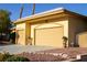 Spacious three-car garage featuring an arched entrance and well-maintained landscaping at 4554 Blue Mesa Way, Las Vegas, NV 89129