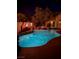 Inviting pool and spa area at night, featuring fire bowls and tranquil lighting at 4554 Blue Mesa Way, Las Vegas, NV 89129