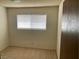 Bedroom with beige carpet, a window providing natural light, and closet access at 4564 Dennis Way, Las Vegas, NV 89121