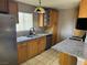 Galley kitchen with stainless appliances, granite countertops, light wood cabinets and gas range at 4778 Beadle St, Las Vegas, NV 89122