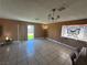 Living room with tile flooring, ceiling fan, and sliding glass door to the backyard at 4778 Beadle St, Las Vegas, NV 89122