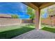 This backyard features a patio, faux grass, mature trees, and a wall at 484 Merseyside Dr, Las Vegas, NV 89178