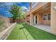 Backyard with artificial grass, brick perimeter walls, and covered patio at 484 Merseyside Dr, Las Vegas, NV 89178