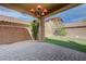Beautiful backyard featuring a covered patio, decorative chandelier, and manicured artificial grass at 484 Merseyside Dr, Las Vegas, NV 89178