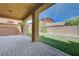 Relaxing backyard featuring a covered patio, artificial grass and brick perimeter walls at 484 Merseyside Dr, Las Vegas, NV 89178