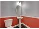 Cozy powder room with pedestal sink, decorative mirror, and two-tone walls with elegant wainscoting detail at 484 Merseyside Dr, Las Vegas, NV 89178