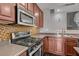 Updated kitchen featuring modern appliances, mosaic backsplash, and dark wood cabinetry with ample counter space at 484 Merseyside Dr, Las Vegas, NV 89178