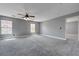 Upstairs loft area with plush gray carpet, two windows, ceiling fan, and neutral gray walls at 484 Merseyside Dr, Las Vegas, NV 89178