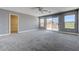 Large main bedroom with neutral carpet, ceiling fan, balcony access and large walk-in closet at 484 Merseyside Dr, Las Vegas, NV 89178