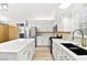 Modern kitchen with white cabinets, stainless steel appliances, quartz countertops and an island at 5009 Elm Grove Dr, Las Vegas, NV 89130