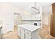 Bright kitchen featuring white cabinets, quartz countertops and a center island, next to a dining area at 5009 Elm Grove Dr, Las Vegas, NV 89130