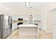Bright kitchen featuring white cabinets, stainless steel appliances, quartz countertops and a center island at 5009 Elm Grove Dr, Las Vegas, NV 89130