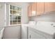 Bright laundry room featuring a window, natural light, and convenient overhead cabinet storage at 5009 Elm Grove Dr, Las Vegas, NV 89130