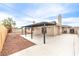 A concrete patio with a pergola offers an inviting outdoor space with gravel and a privacy fence at 516 Donner St, Las Vegas, NV 89107