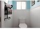 Cozy powder room featuring a white toilet, paneled walls, and a unique shelving unit at 5260 Styers St, North Las Vegas, NV 89031