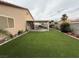 Well maintained backyard with artificial grass, patio, and a covered seating area at 5318 Rio Eldorado Ct, North Las Vegas, NV 89031