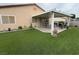 Backyard featuring artificial grass, a covered patio, and a landscaped area at 5318 Rio Eldorado Ct, North Las Vegas, NV 89031