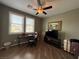 This bedroom features a ceiling fan, two windows for natural light, and dark wood floors at 5318 Rio Eldorado Ct, North Las Vegas, NV 89031