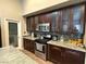 Modern kitchen featuring stainless steel appliances, mosaic backsplash, and dark wood cabinets at 5318 Rio Eldorado Ct, North Las Vegas, NV 89031