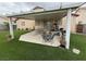 Covered patio features seating and outdoor cooking area, plus landscaped backyard with artificial grass at 5318 Rio Eldorado Ct, North Las Vegas, NV 89031