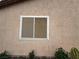 Exterior view of a window framed in white trim, set in stucco and surrounded by plants at 5318 Rio Eldorado Ct, North Las Vegas, NV 89031