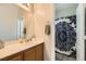 Well-lit bathroom featuring a single sink vanity and shower with decorative curtain at 5409 Cruz Crest Ct, North Las Vegas, NV 89081
