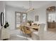 Dining room featuring a modern chandelier, light wood table and chairs, and double doors to the backyard at 5737 Heather Breeze Ct, Las Vegas, NV 89141