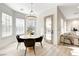 Sunlit dining area with a round table, chandelier, and access to the living room at 5737 Heather Breeze Ct, Las Vegas, NV 89141