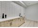 Well-lit laundry room with a countertop, wooden cabinets, black hardware, and modern design at 5737 Heather Breeze Ct, Las Vegas, NV 89141