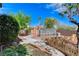 The backyard includes a greenhouse, garden plots, walkway and mature trees, creating a relaxing outdoor space at 5949 Casa Coronado Ave, Las Vegas, NV 89131