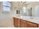 Bathroom with a double vanity, a large mirror, and a window at 5949 Casa Coronado Ave, Las Vegas, NV 89131