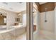 Well-lit bathroom with a large soaking tub, dual vanities, and a separate walk-in shower at 5949 Casa Coronado Ave, Las Vegas, NV 89131