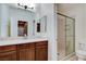 Bathroom featuring a framed mirror, wood vanity, solid surface counter, and glass-enclosed shower at 5949 Casa Coronado Ave, Las Vegas, NV 89131