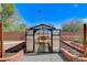 Bright greenhouse with shelving and gravel flooring ready for cultivating plants and extending the growing season at 5949 Casa Coronado Ave, Las Vegas, NV 89131