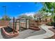 Backyard featuring a greenhouse, garden beds, gravel pathway, and mature trees offering tranquil outdoor retreat at 5949 Casa Coronado Ave, Las Vegas, NV 89131