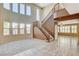 Spacious living room with high ceilings, large windows, a staircase, and a mix of carpet and tile flooring at 5949 Casa Coronado Ave, Las Vegas, NV 89131