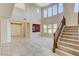 Bright living room with high ceilings, many windows, tile flooring, a carpeted seating area, and a staircase at 5949 Casa Coronado Ave, Las Vegas, NV 89131